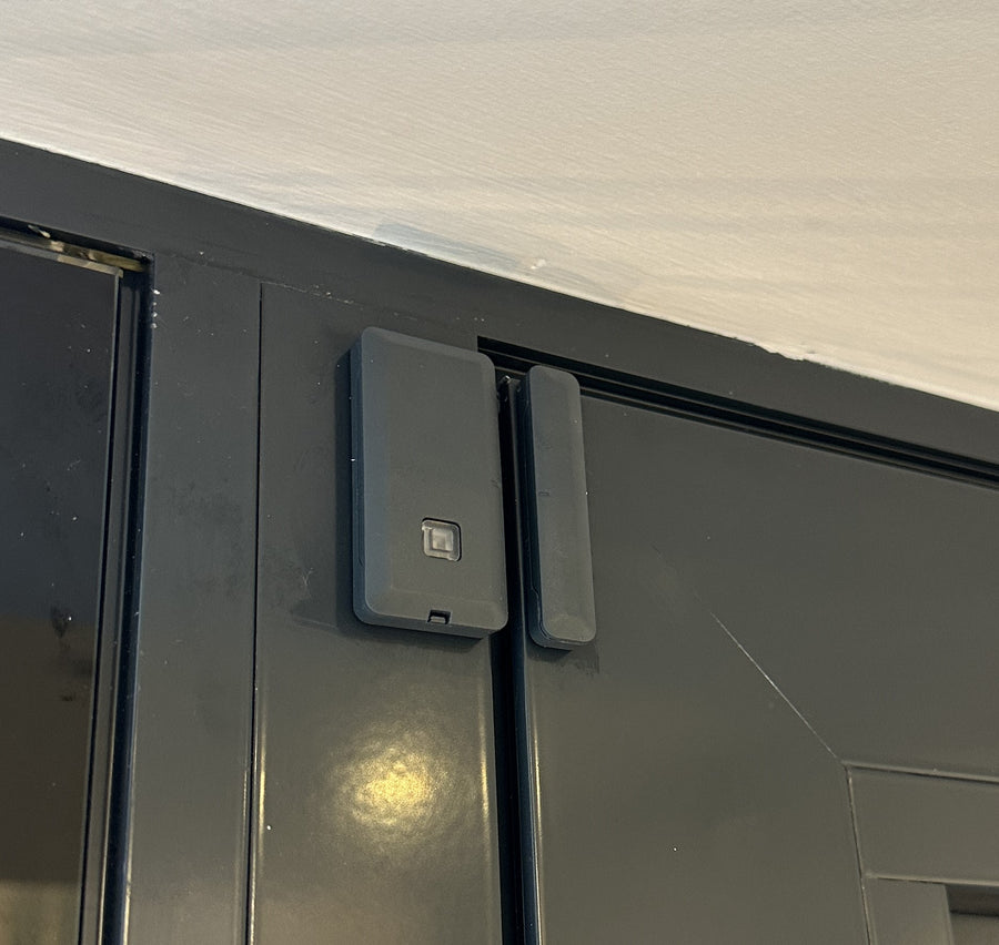 Texecom alarm door contact installed on a dark door